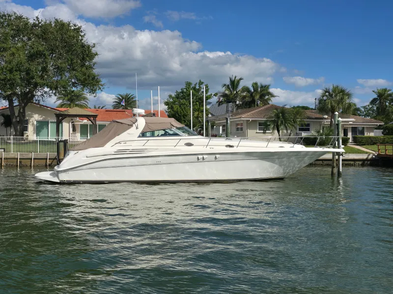 The Image of 1998 Sea Ray 450 Sundancer yacht docked by waterfront. - 0