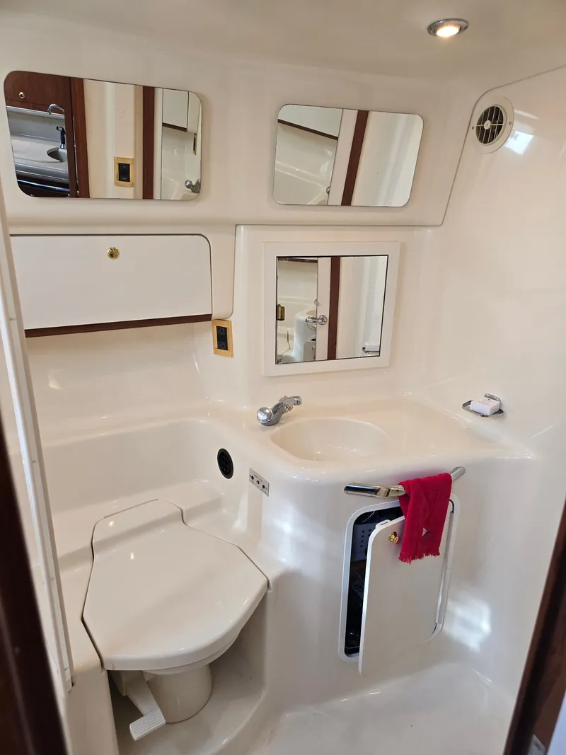 Slide: The Image of 1998 Sea Ray 450 Sundancer bathroom with mirrors and sink. - 21