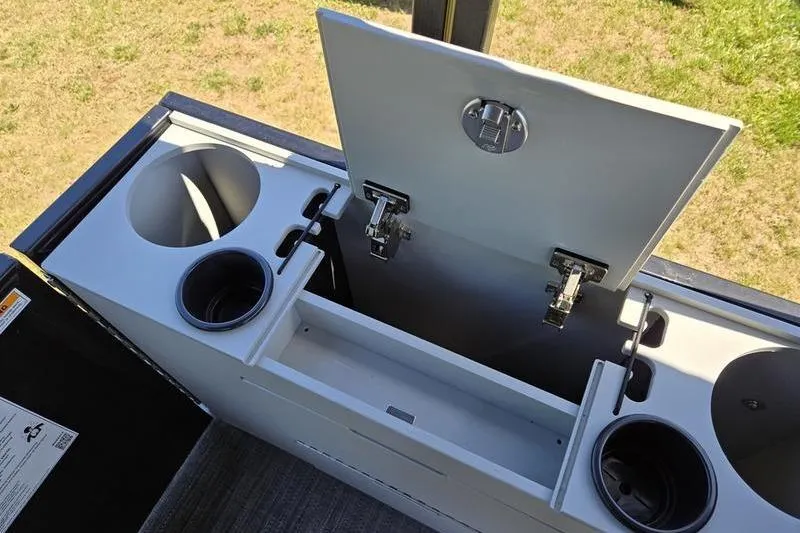 Slide: The Image of Open storage compartment on 2024 Godfrey Mighty G 1476 C boat, featuring cup holders. - 13