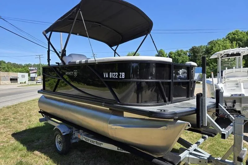 Slide: The Image of 2024 Godfrey Mighty G 1476 C pontoon boat on trailer, parked outdoors. - 3