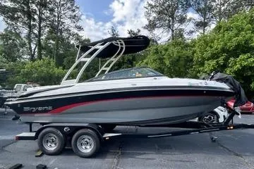 The Image of 2019 Bryant 210 boat on trailer, parked outdoors with trees in background. - 0