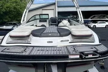 Slide: The Image of 2019 Bryant 210 boat with sleek design and spacious seating, parked outdoors. - 2