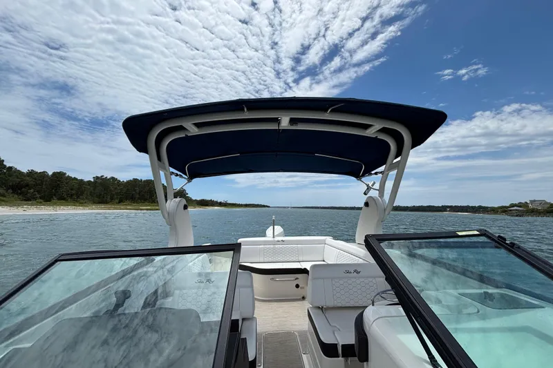 Slide: The Image of 2019 Sea Ray SDX 270 Outboard boat cruising on a scenic waterway under a blue sky. - 18