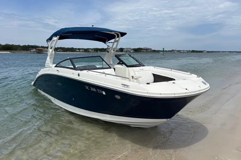 Slide: The Image of 2019 Sea Ray SDX 270 Outboard boat on sandy shore with blue canopy. - 3