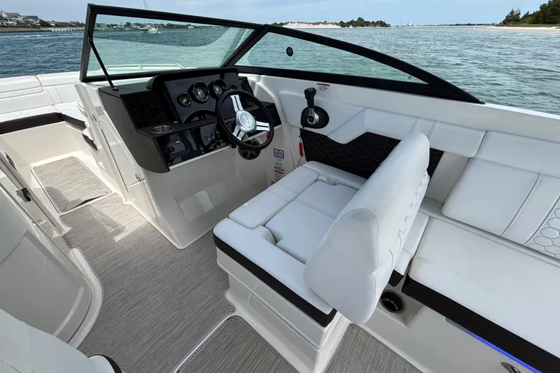 Slide: The Image of 2019 Sea Ray SDX 270 Outboard boat interior with steering wheel and seating, on calm water. - 36