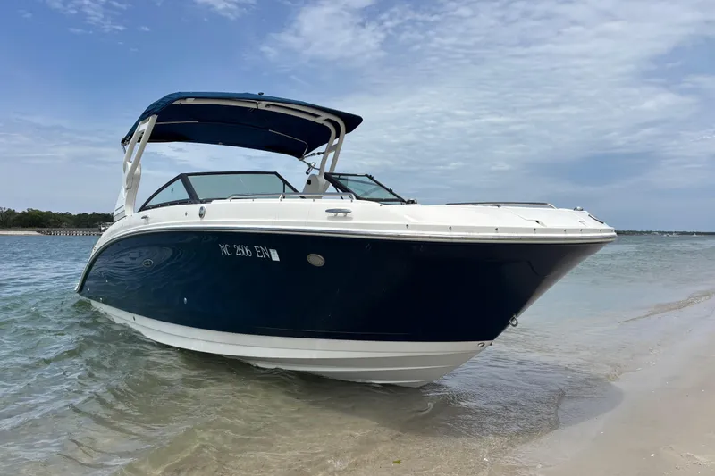 Slide: The Image of 2019 Sea Ray SDX 270 Outboard boat on sandy shore under blue sky. - 4