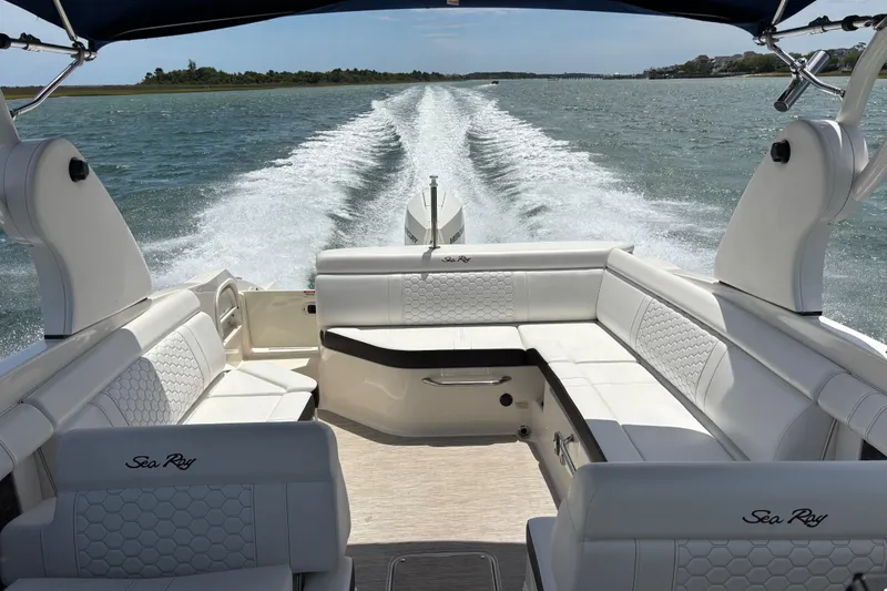 Slide: The Image of 2019 Sea Ray SDX 270 Outboard cruising on open water, featuring luxurious seating and wake trail. - 54