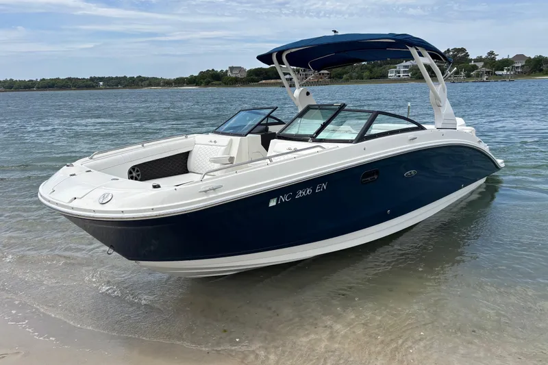 Slide: The Image of 2019 Sea Ray SDX 270 Outboard boat docked on a sandy shore. - 6