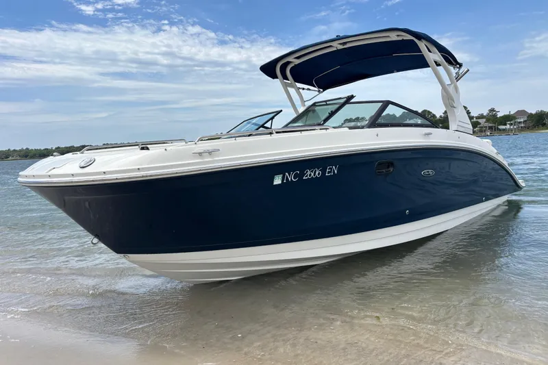Slide: The Image of 2019 Sea Ray SDX 270 Outboard boat on sandy shore with blue canopy. - 7