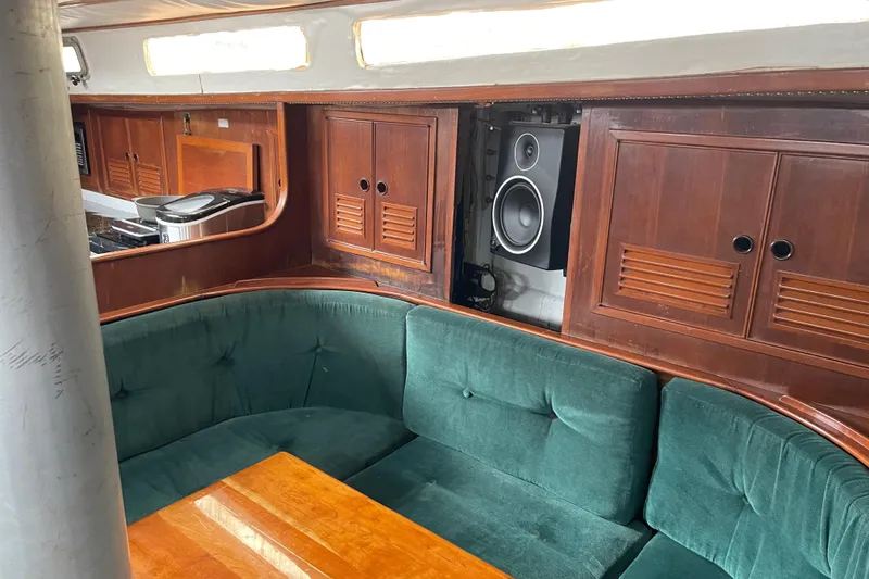 Slide: The Image of Cozy 1984 TA Chaio CT47 yacht interior with green seating and wooden cabinets. - 11