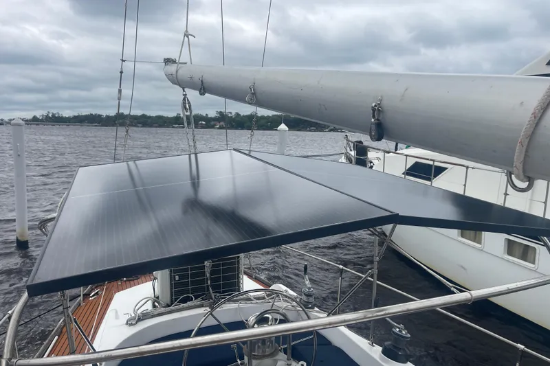 Slide: The Image of Sailboat with solar panels on deck, TA Chaio CT47, 1984 model, docked on a cloudy day. - 13