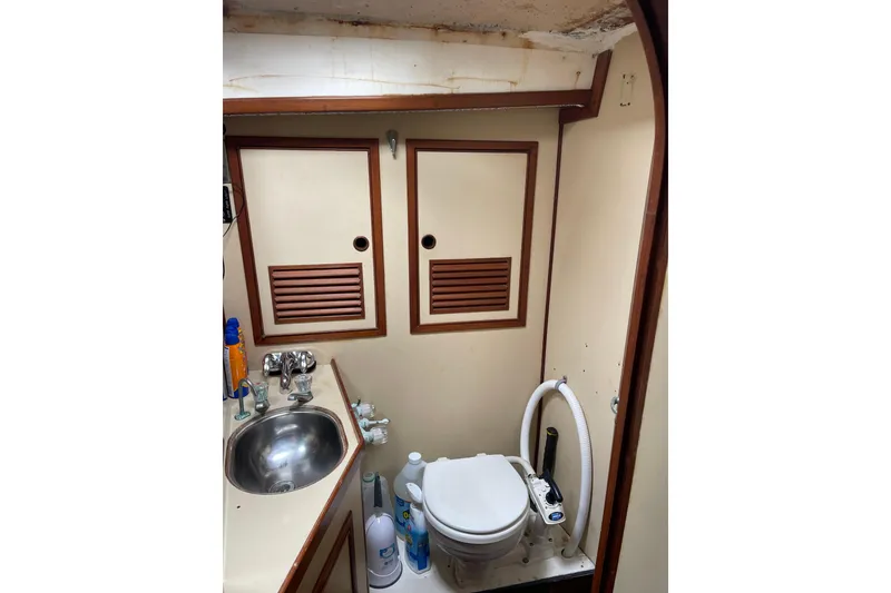 Slide: The Image of Compact 1984 TA Chaio CT47 boat bathroom with sink, toilet, and storage cabinets. - 14
