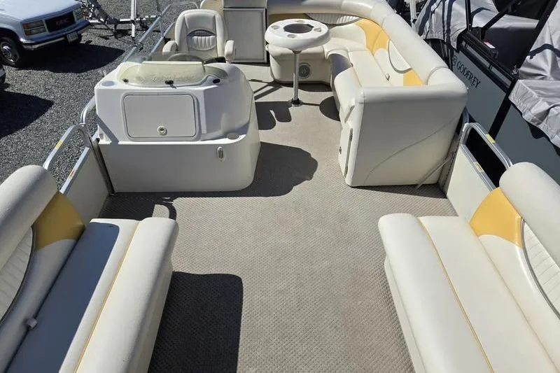 Slide: The Image of 2008 Sweetwater 2386RE pontoon boat interior with beige seating and table. - 17