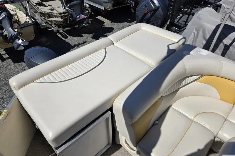 Slide: The Image of 2008 Sweetwater 2386RE boat interior with beige seating and storage compartments. - 9