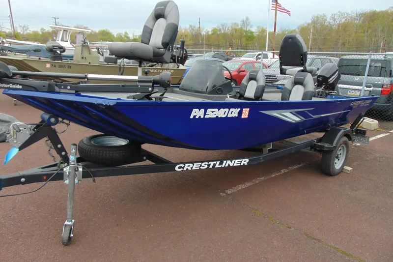Slide: The Image of 2020 Crestliner 1700 Storm boat in blue, parked on a trailer in a lot. - 3