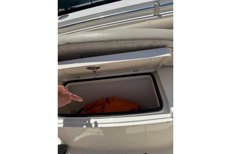 Slide: The Image of Storage compartment on a 2015 Cobia 296 Center Console boat, containing safety equipment. - 14
