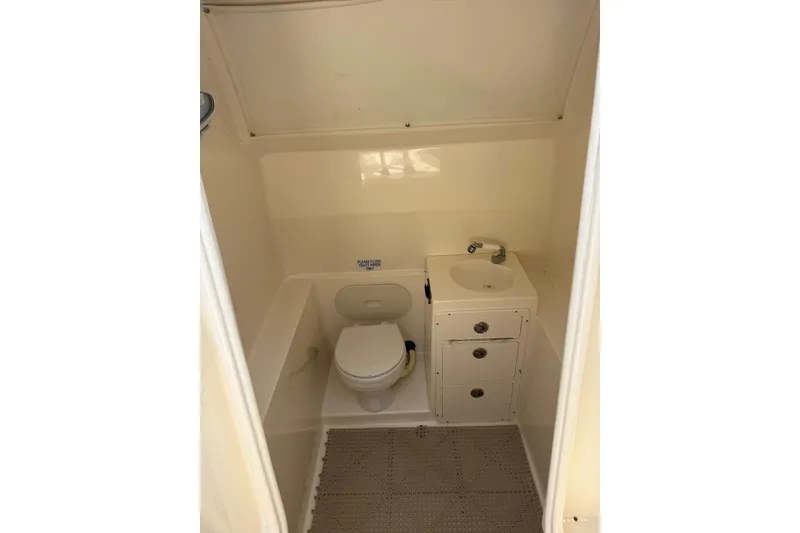 Slide: The Image of 2015 Cobia 296 Center Console boat bathroom with toilet and sink. - 16