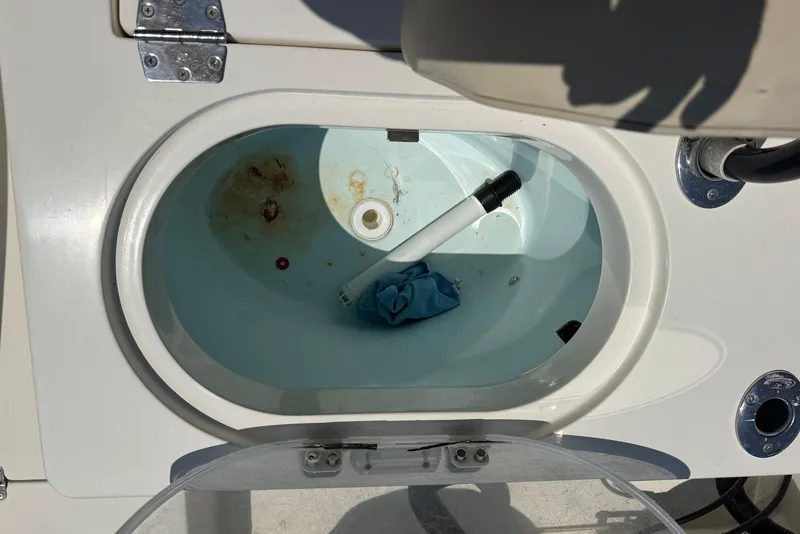 Slide: The Image of Livewell interior of 2015 Cobia 296 Center Console boat, showing water and debris. - 6