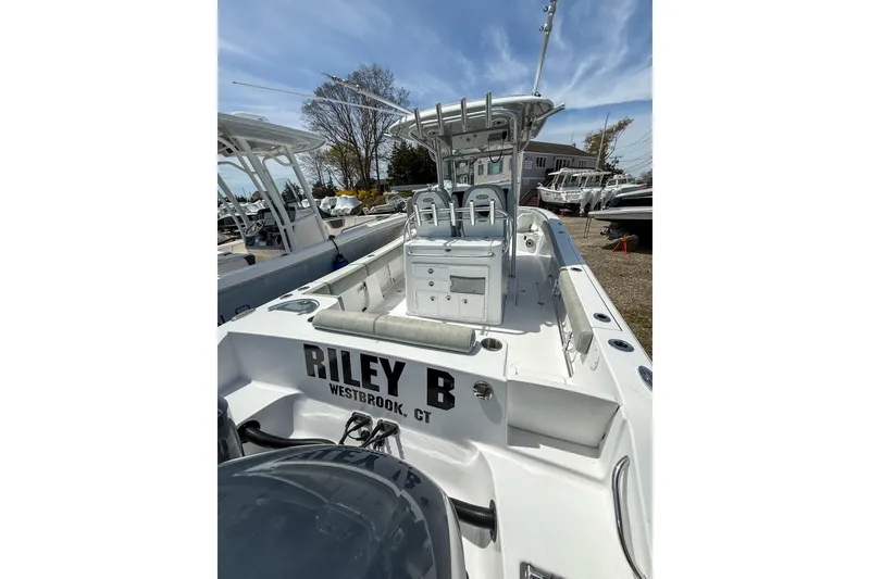 Slide: The Image of 2019 Sportsman Open 282 Center Console boat docked, featuring spacious deck and seating. - 15
