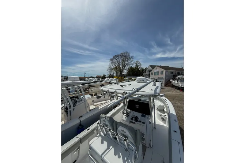 Slide: The Image of 2019 Sportsman Open 282 Center Console boat docked under a clear blue sky. - 16