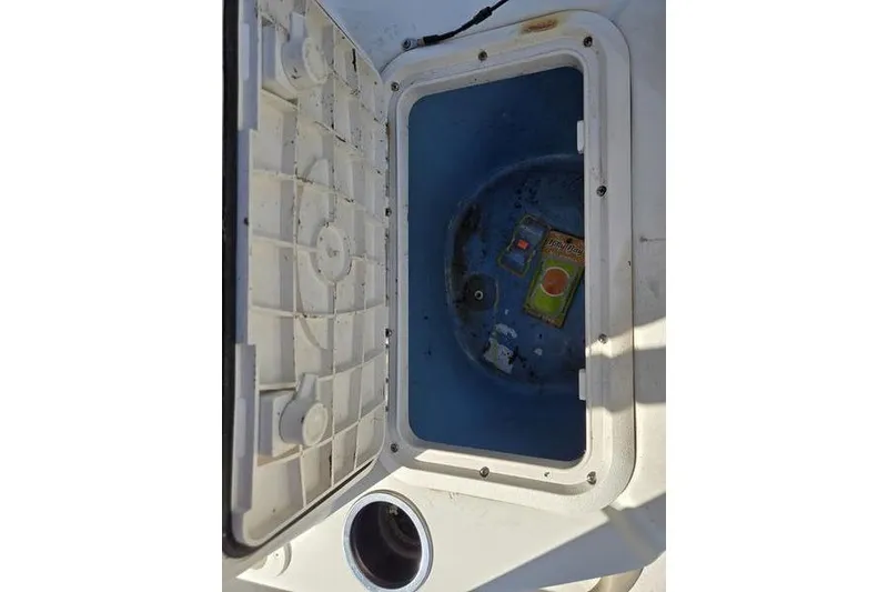 Slide: The Image of Open storage compartment in a 2017 Carolina Skiff 19 DLX boat, showing interior contents. - 13