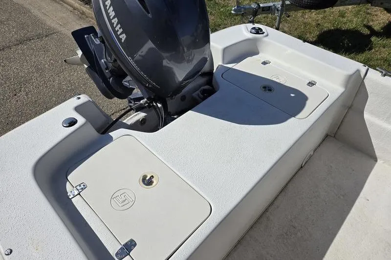 Slide: The Image of 2017 Carolina Skiff 19 DLX boat with Yamaha outboard motor, featuring storage compartments. - 15