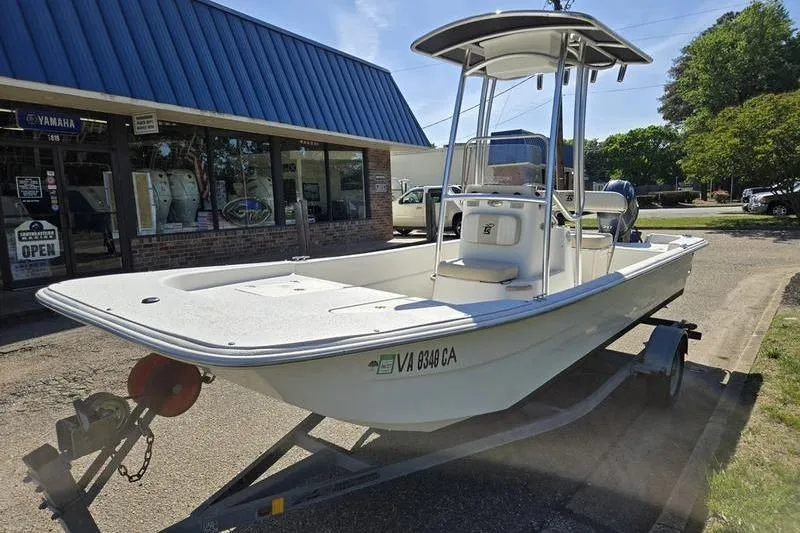 Slide: The Image of 2017 Carolina Skiff 19 DLX boat on trailer outside a marine store. - 4