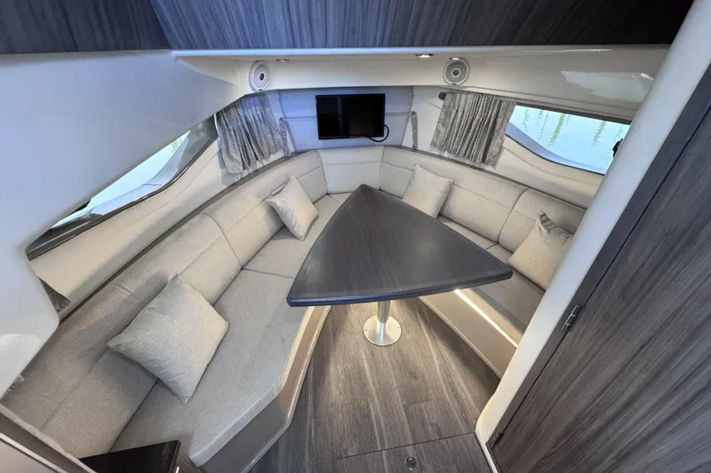 Slide: The Image of Interior of 2021 Sea Ray Sundancer 320 with elegant seating and triangular table. - 11