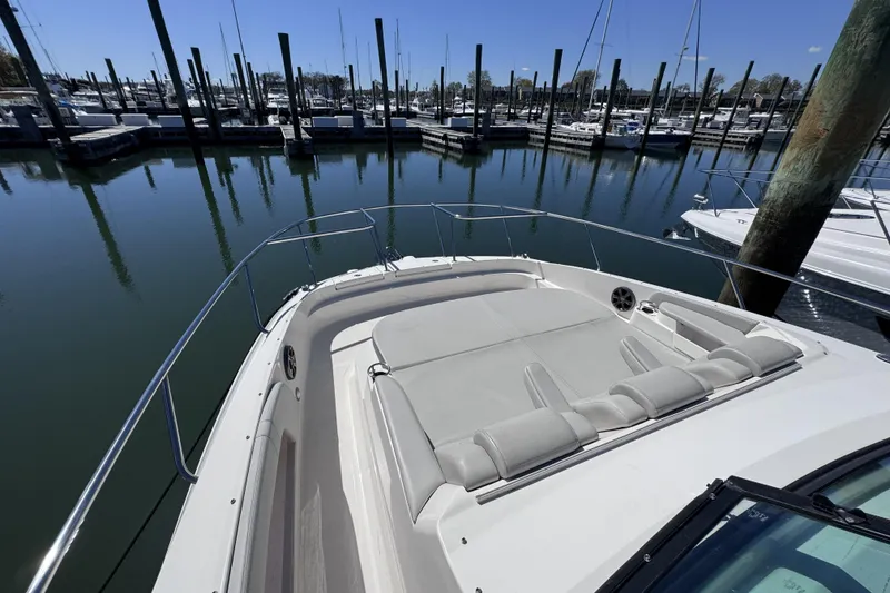 Slide: The Image of 2021 Sea Ray Sundancer 320 yacht docked in a marina, showcasing spacious deck seating. - 15