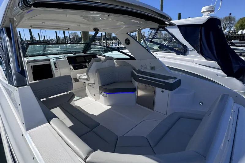 Slide: The Image of 2021 Sea Ray Sundancer 320 interior with modern seating and helm, docked at marina. - 3