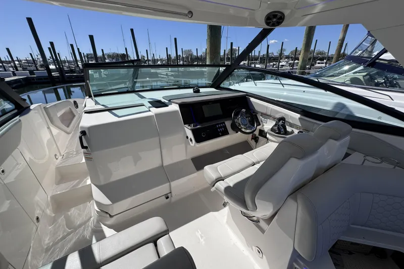 Slide: The Image of 2021 Sea Ray Sundancer 320 cockpit with modern helm and seating at marina. - 8