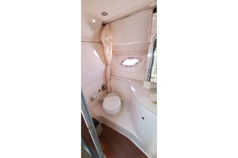 Slide: The Image of 2016 Regal 35 Sport Coupe bathroom interior with toilet, sink, and porthole window. - 13