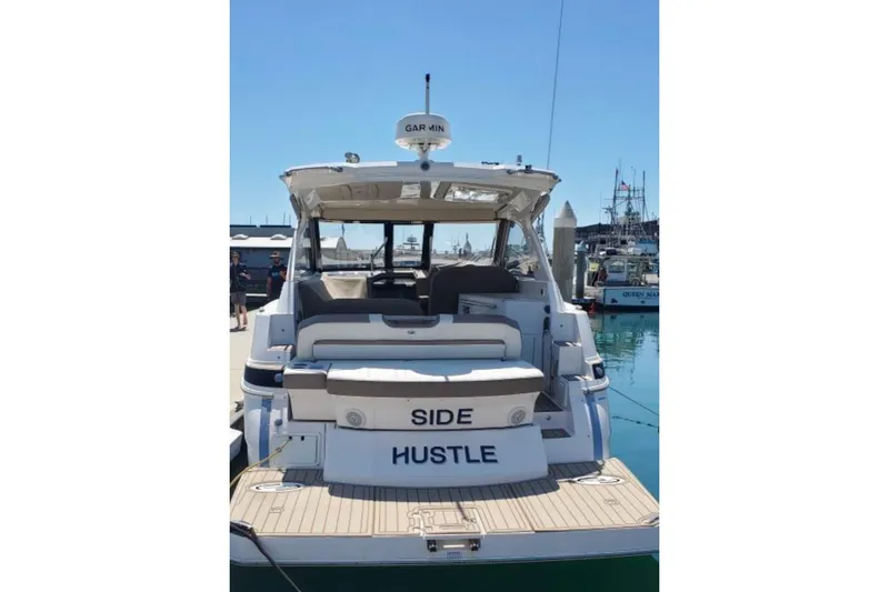 Slide: The Image of 2016 Regal 35 Sport Coupe yacht named "Side Hustle" docked at a marina. - 2