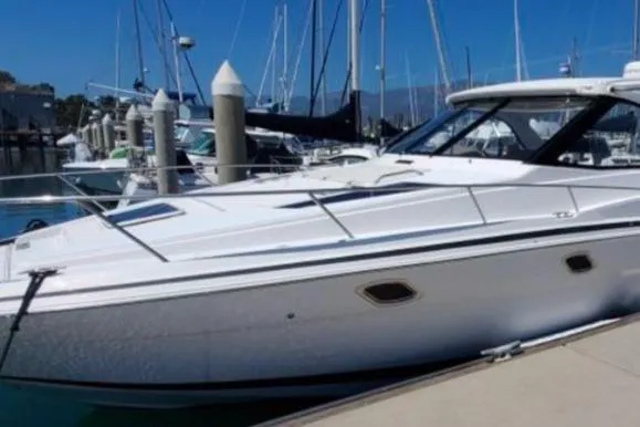 Slide: The Image of 2016 Regal 35 Sport Coupe yacht docked at a marina with sailboats in the background. - 3