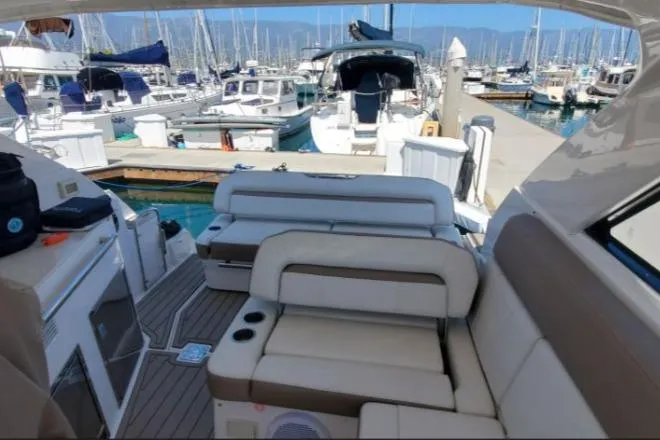Slide: The Image of 2016 Regal 35 Sport Coupe interior with seating, docked at a marina with multiple boats. - 6
