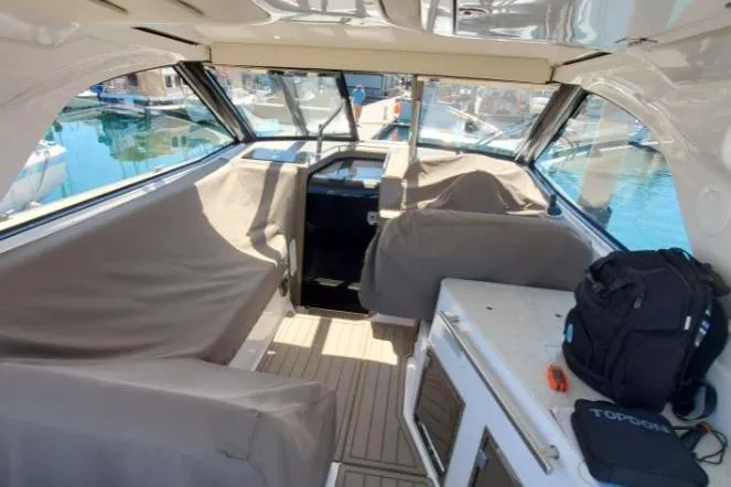Slide: The Image of Interior of a 2016 Regal 35 Sport Coupe boat with covered seating and helm. - 7
