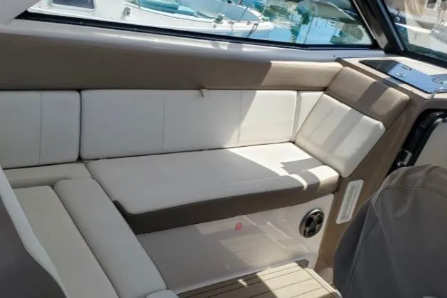 Slide: The Image of Interior seating of a 2016 Regal 35 Sport Coupe boat, featuring white and beige upholstery. - 8