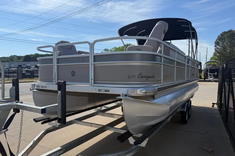 Slide: The Image of 2008 Premier 250 Escapade pontoon boat on trailer, parked outdoors under blue sky. - 4