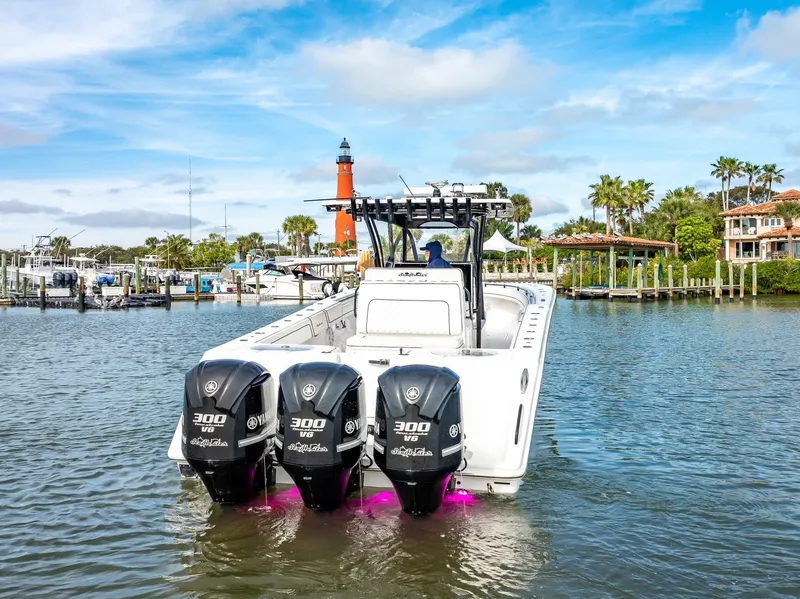 Slide: The Image of 2020 SeaHunter 35 Tournament boat with triple 300 HP engines in a marina. - 19