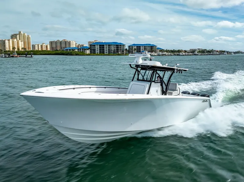 The Image of 2020 SeaHunter 35 Tournament boat cruising on water near coastal buildings. - 2