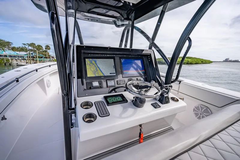 Slide: The Image of 2020 SeaHunter 35 Tournament boat console with navigation screens and steering wheel. - 26