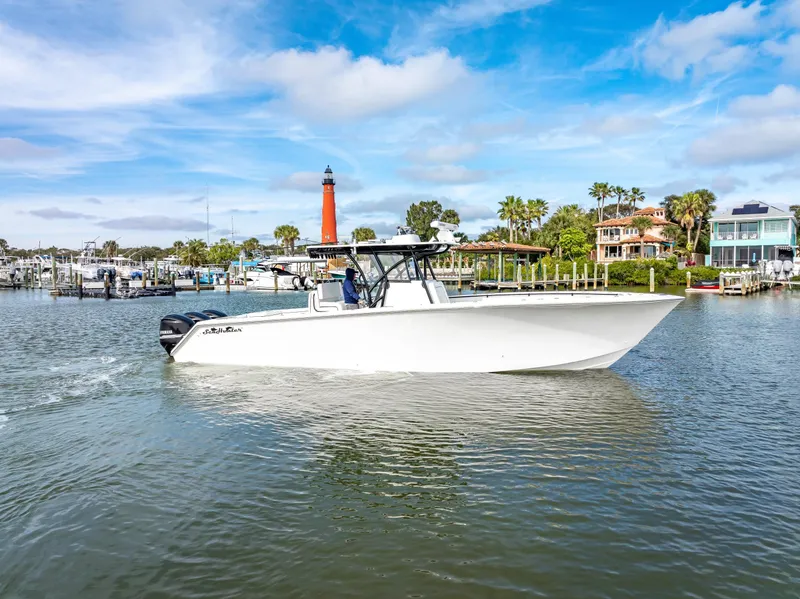 Slide: The Image of 2020 SeaHunter 35 Tournament boat cruising near a marina with a lighthouse in the background. - 7