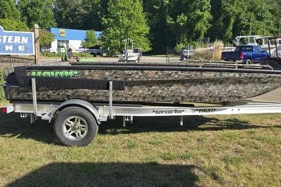 The Image of 2026 Havoc 1860 DBST boat on trailer, camo design, parked outdoors. - 0