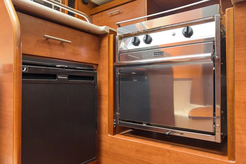 Slide: The Image of Compact kitchen area in a 2015 Hunter 33 yacht with oven and fridge. - 10
