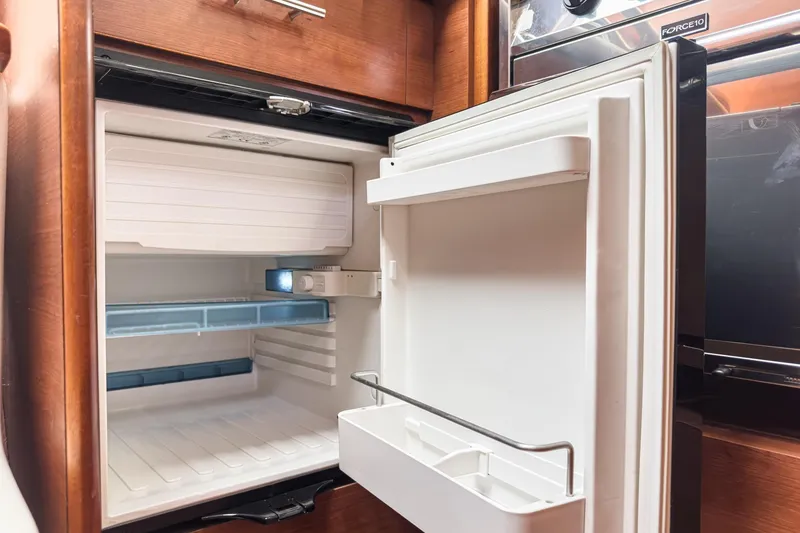 Slide: The Image of Open refrigerator inside a 2015 Hunter 33 yacht, showcasing interior storage space. - 11