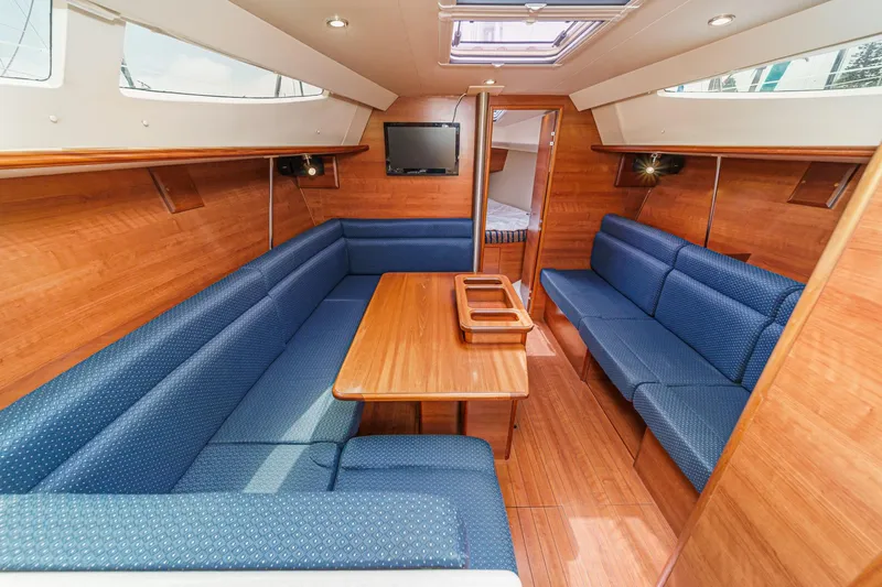 Slide: The Image of Interior of a 2015 Hunter 33 sailboat with blue seating and wooden finishes. - 13