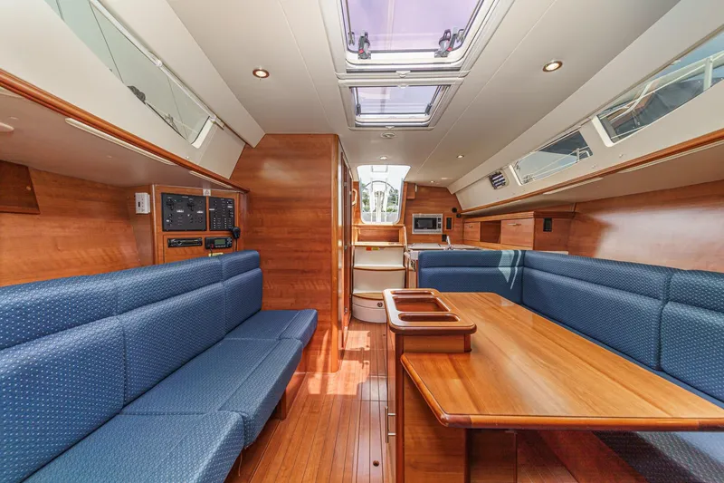 Slide: The Image of Interior of 2015 Hunter 33 sailboat with wood finish and blue seating. - 15