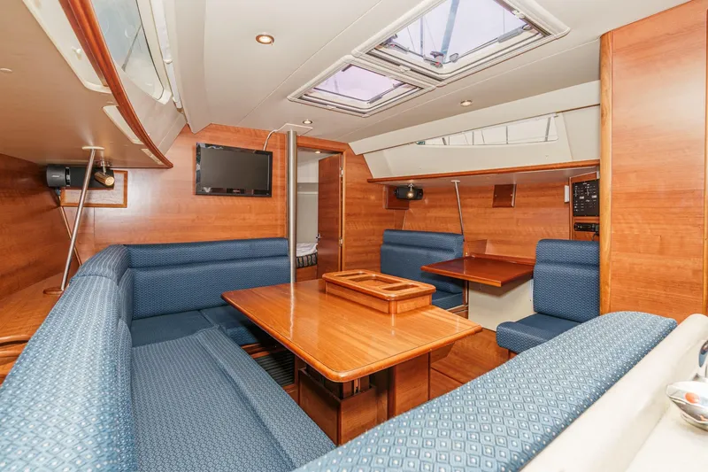 Slide: The Image of Interior of 2015 Hunter 33 sailboat with wood finish and blue seating. - 17