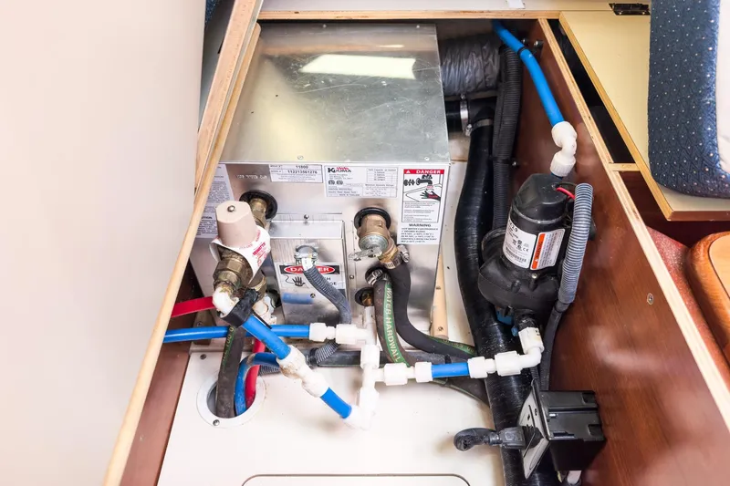 Slide: The Image of Interior view of a 2015 Hunter 33 boat's plumbing system with pipes and valves. - 28