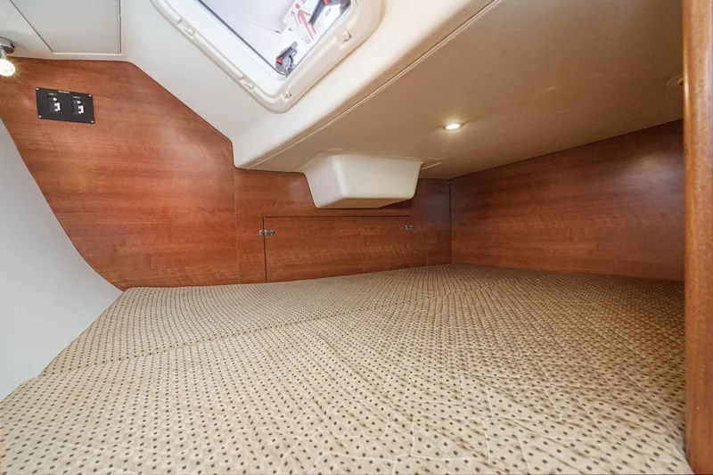 Slide: The Image of Interior cabin of a 2015 Hunter 33 sailboat with wood paneling and cozy bedding. - 30